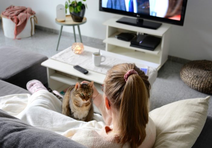 domestic-life-with-pet-a-young-woman-is-sitting-on-the-couch-in-the-living-room-with-her-cute-cat-she_t20_wl8kk8